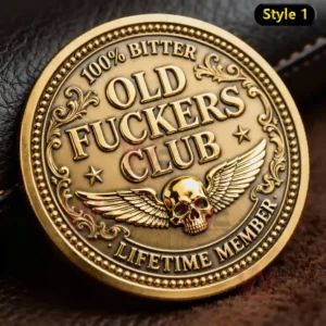 A gold tone commemorative coin with engraved text ornate borders and a winged skull motif!