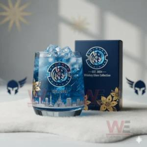 Orlando Valkyries Whiskey Glass 5 A blue Orlando Valkyries glass with ice sits on a white surface next to its matching box with wing emblems in the background!