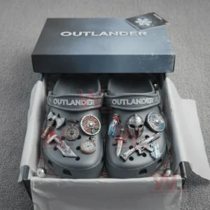 Gray Outlander clogs in a gift box decorated with charms shaped like shields axes pocket watches daggers and rustic items.