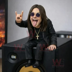 Collectible rock star figure in black suit with long hair and round sunglasses sitting on a speaker making a rock hand sign and sticking out the tongue.