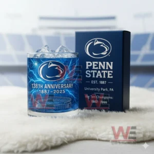 Penn State Nittany Lions 138th Anniversary 1887-2025 Whiskey Glass 6 A blue Penn State themed ice filled glass beside a matching box on a soft white rug with a stadium backdrop!