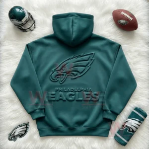 Philadelphia Eagles Embossed Hoodie 3 Flat lay of a green Philadelphia Eagles hoodie with raised logo surrounded by football accessories!
