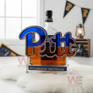 A Pitt logo bottle with amber liquid on white fur with Pitt banners in the background.