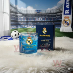 A Real Madrid anniversary glass with blue ice shown in front of a stadium themed background.