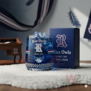 Rice Owls whiskey glass with ice and blue liquid placed on a soft surface with a branded box in a sports themed room!