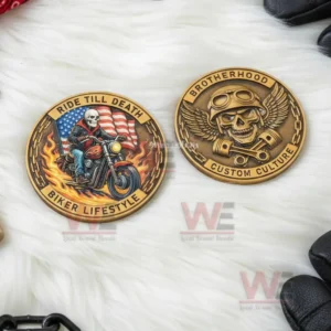 Two biker lifestyle coins with skull designs resting on a white fluffy surface!