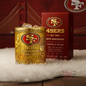 San Francisco 49ers 80th Anniversary 1946-2026 Faithful To The Bay Whiskey Glass 4 Golden San Francisco 49ers anniversary glass with amber iced drink beside a red box in a setting with a Golden Gate Bridge backdrop!