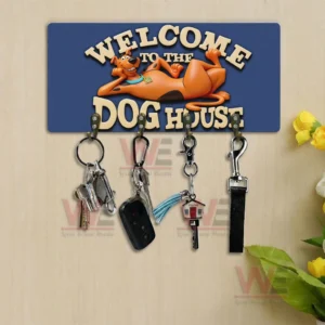 Scooby Doo Welcome to the Dog House Personalized Wall Key Holder 6 Blue Welcome To The Dog House wall key holder with lounging cartoon dog and five hooks holding keys and keychains displayed on a light wood wall with flowers!