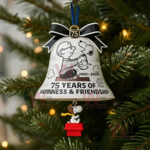 A decorative bell ornament with a printed scene of a boy and a dog and a small dog figure hanging below displayed among Christmas tree branches!
