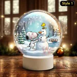 A snow globe showing Snoopy building a snowman with a yellow bird on top in a snowy forest scene!