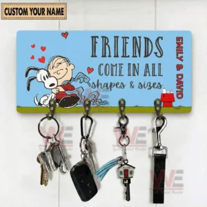 Personalized Friends come in all shapes and sizes key holder plaque with Emily and David names and four hooks holding keys and accessories on a white wall.