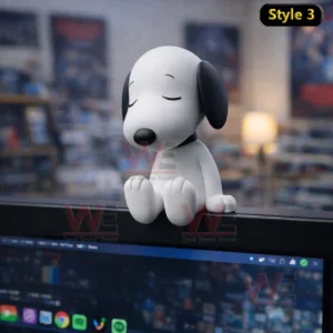 Snoopy desk figure sitting with closed eyes on a computer monitor in a calm indoor setting!