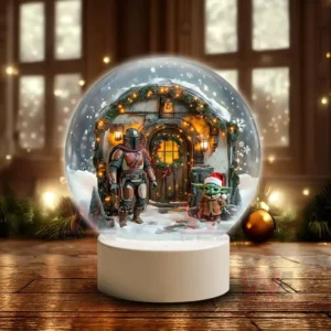 A snow globe showing an armored figure and a small green child in a red hat standing outside a warmly lit snow covered house decorated for the holidays!