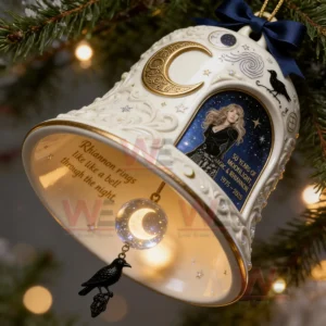 A decorative anniversary bell ornament shown on a tree branch with moon and star designs a mystical portrait and a hanging sphere with a raven charm!