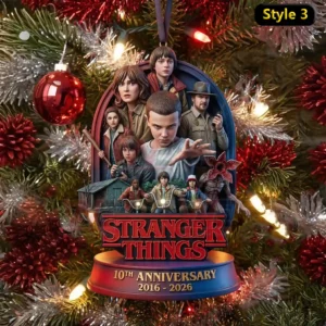 Stranger Things 10th Anniversary 2016-2026 Ornament 7 The image displays a Stranger Things ornament featuring the main cast posed together in front of festive red and silver decorations.