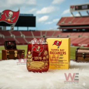 A red and gold Buccaneers glass with ice and a yellow box displayed on a white surface inside a stadium environment!