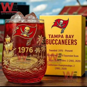 A detailed red and gold Buccaneers glass with ice shown next to a yellow information box in a stadium setting!