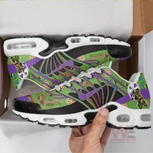 A hand lifts brightly patterned sneakers from a box highlighting the turtle graphics and vivid green surface!