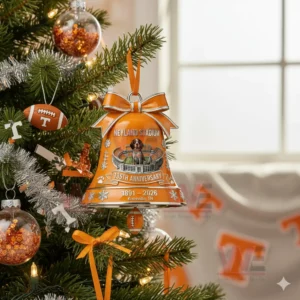 A close view of an orange stadium themed bell ornament with a dog mascot hanging on a decorated Christmas tree!