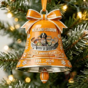 A detailed orange bell ornament featuring a stadium design and small football charm hanging on a lit Christmas tree!