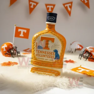 Tennessee Volunteers 134th Anniversary 1891-2025 Whiskey Bottle 6 Orange Tennessee Volunteers anniversary bottle with dark cap on a white rug surrounded by small helmets flags and fall leaves!