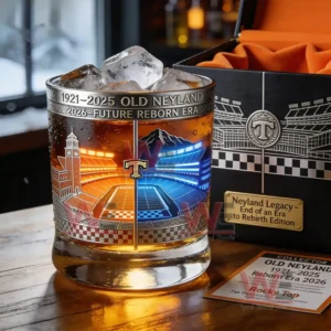 Commemorative whiskey glass with ice and stadium artwork placed on a table next to a collector box!
