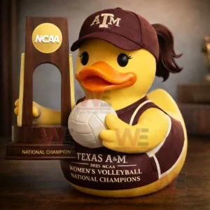 Yellow rubber duck in Texas A and M cap and jersey holding a volleyball next to an NCAA national champion trophy.