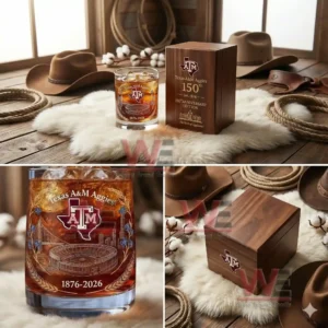 A Texas A M Aggies themed anniversary glass standing beside a wooden box on a fluffy surface with cowboy hats and ropes in the background!