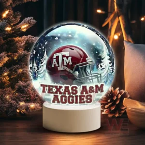 Illuminated glass sphere with Texas A M Aggies helmet against a snowy background on a white base!