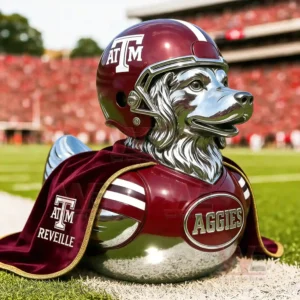 A polished mascot duck figure with a football helmet and flowing cape positioned on green turf inside a large football stadium!
