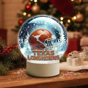 Illuminated glass sphere with Texas Longhorns helmet against a snowy background on a white base!