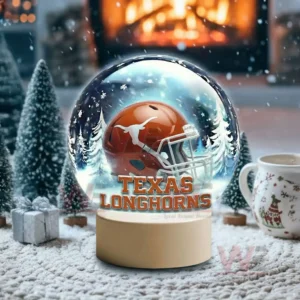 Texas Longhorns LED Snow Globe Night Light Christmas Ornament 5 Snow globe style display featuring a Texas Longhorns helmet on a white base near fireplace and winter scenery!