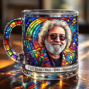 A clear glass mug decorated with a stained glass portrait of a man with curly hair and glasses framed by radiant colorful patterns!