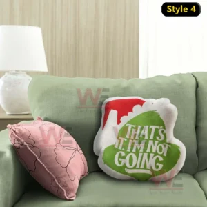 Holiday themed text pillow with green and white design resting on a green sofa with a pink accent pillow!