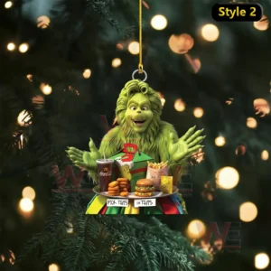 A green character displays a tray of assorted McDonalds food items in front of a bright Christmas tree!