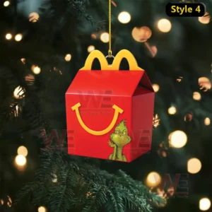 A red McDonalds themed ornament box with a small green character design hangs in front of a festive tree!