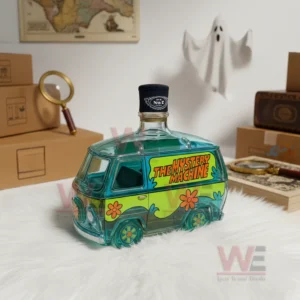 Glass bottle shaped like the Mystery Machine van displayed in a room with boxes a magnifying glass and a ghost decoration.