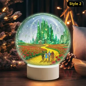 A snow globe showing four travelers heading toward a glowing emerald city on a yellow brick road framed by red flower fields!