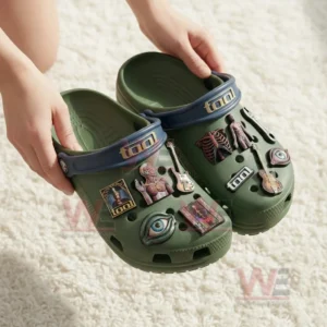 Tool Band Crocs Crocband Clogs With Charms 5 Hands holding green Tool themed clogs with blue straps and charms featuring anatomy art guitars an eye and a wrench!