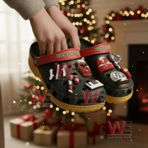Hands holding decorated Twenty One Pilots clogs in a festive room with a Christmas tree behind!