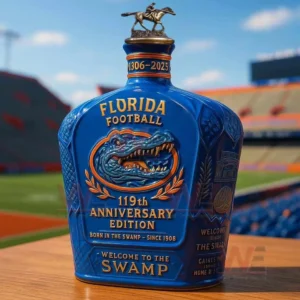 UF Football Florida Gators 119th Anniversary Edition Whiskey Bottle 5 Blue Florida Football anniversary bottle with a horse topper and embossed gator emblem displayed on a wooden table in front of a stadium.