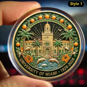 Fingers holding a University of Miami 1926 2026 commemorative coin with a campus tower palm trees oranges flowers and dolphins inside a clear case.