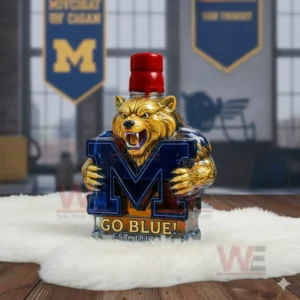 A bear statue with a red top piece holding a blue M emblem placed on a white furry mat in a room decorated with Michigan banners!