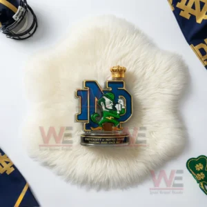A crowned ND emblem with the fighting leprechaun mascot displayed on a white furry mat with Notre Dame decorations around it!