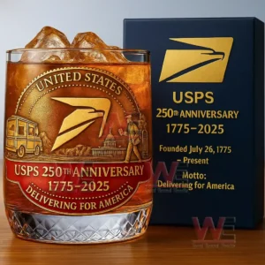 Commemorative whiskey glass with postal themed artwork displayed beside a presentation box on a table!