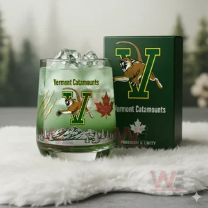 Green Vermont Catamounts whiskey glass with ice mountain illustration and maple leaf shown next to a green box in a serene nature inspired setting!