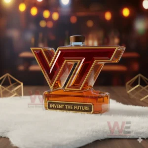 Virginia Tech Hokies Invent The Future Custom Whiskey Bottle 9 A VT shaped amber bottle with a wooden cap placed on a white mat in a warmly lit room!