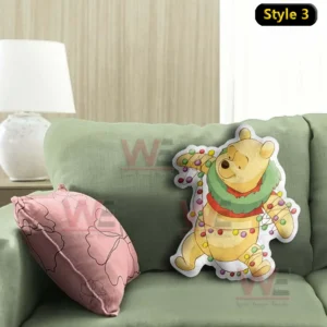 Holiday themed yellow bear pillow wrapped with colorful Christmas lights placed on a green sofa with a pink decorative cushion!