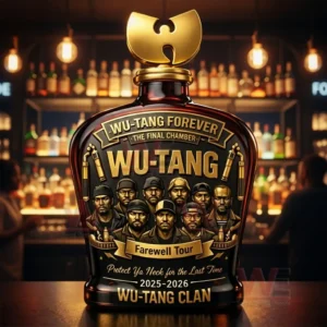 Dark amber whiskey bottle with a gold Wu Tang style cap and farewell tour label featuring illustrated group portraits placed on a bar counter with warm lights and liquor shelves behind!