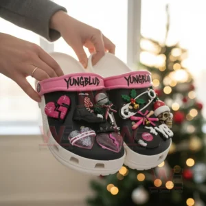 YUNGBLUD Christmas Crocs Clogs with Charms 5 Hands holding Yungblud themed clogs decorated with charms shaped like hearts microphones boots holly safety pins skulls and vinyl records.